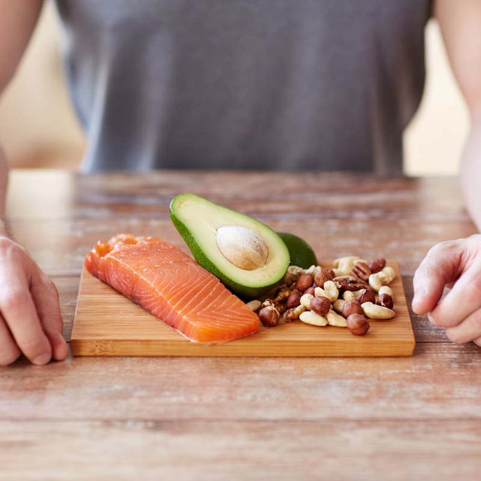 Salmon, avocado and nuts on a chopping board