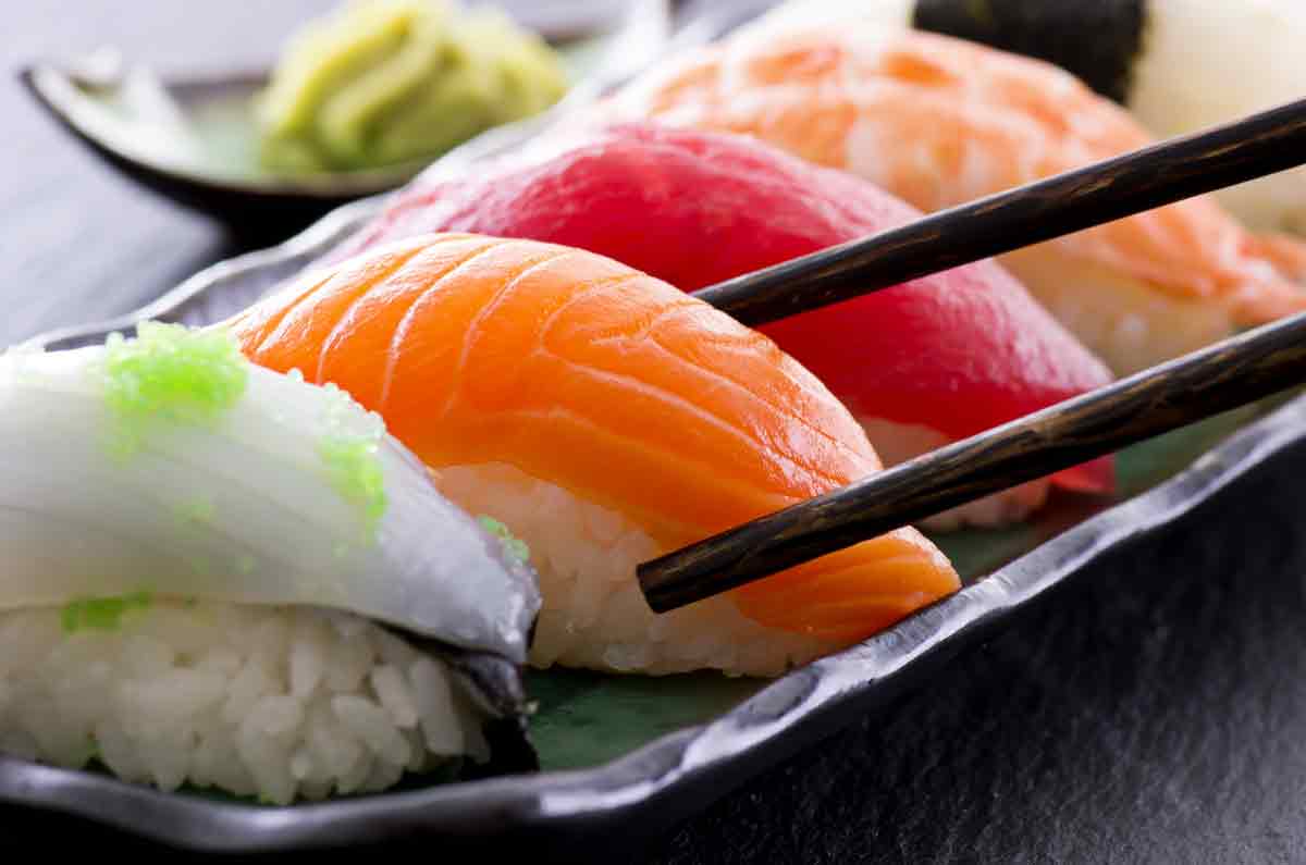 Sushi pieces held with chopsticks
