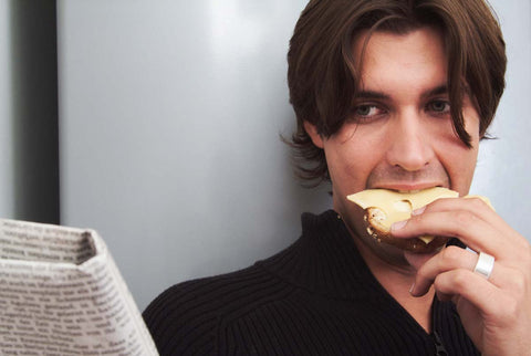 Man eating toast while reading